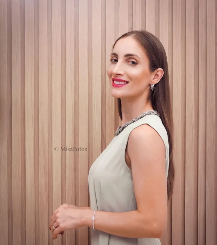 Dra. Camila de Luca em um retrato junto ao painel de madeira